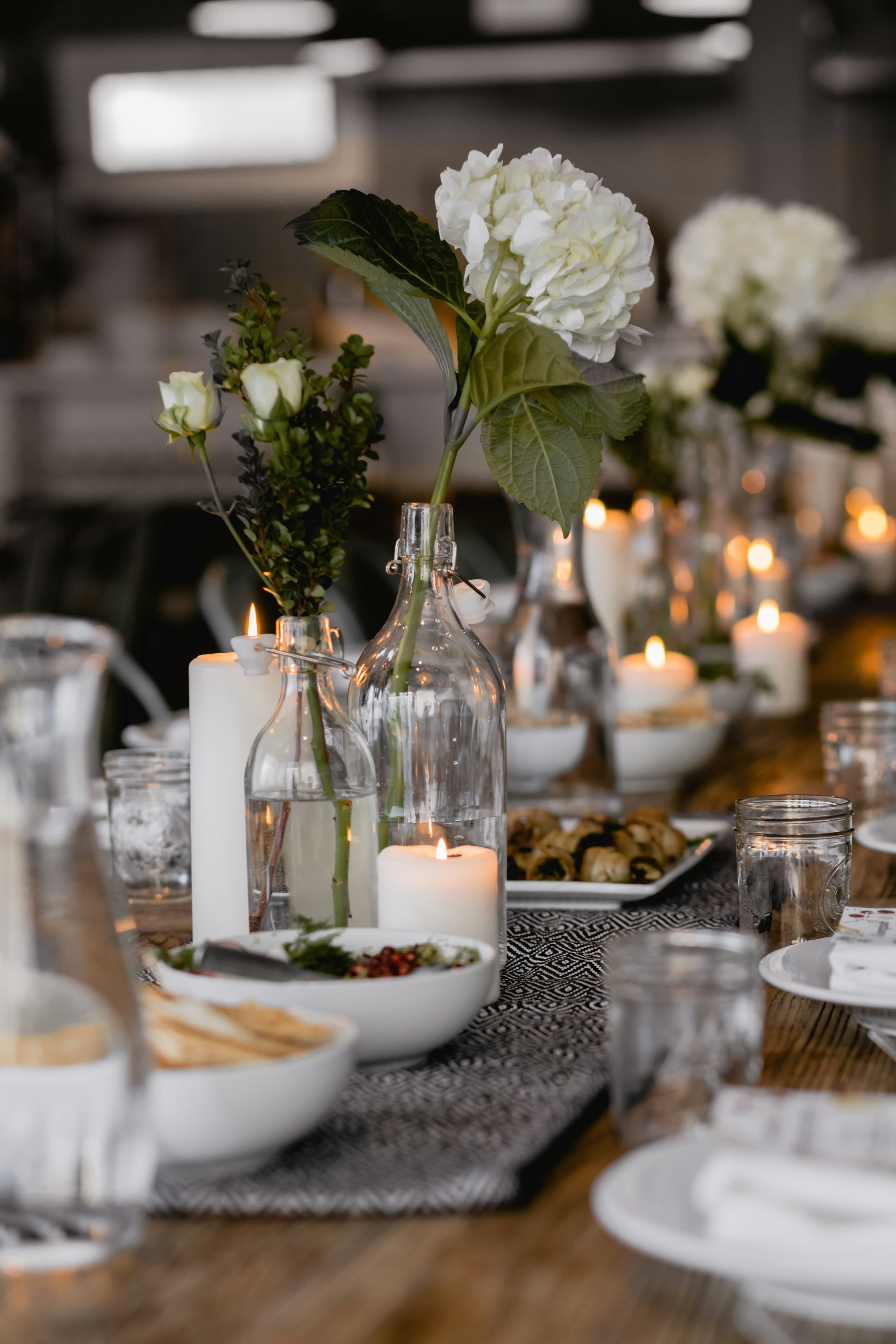 The long table set with flowers, glasses and small plates before service
